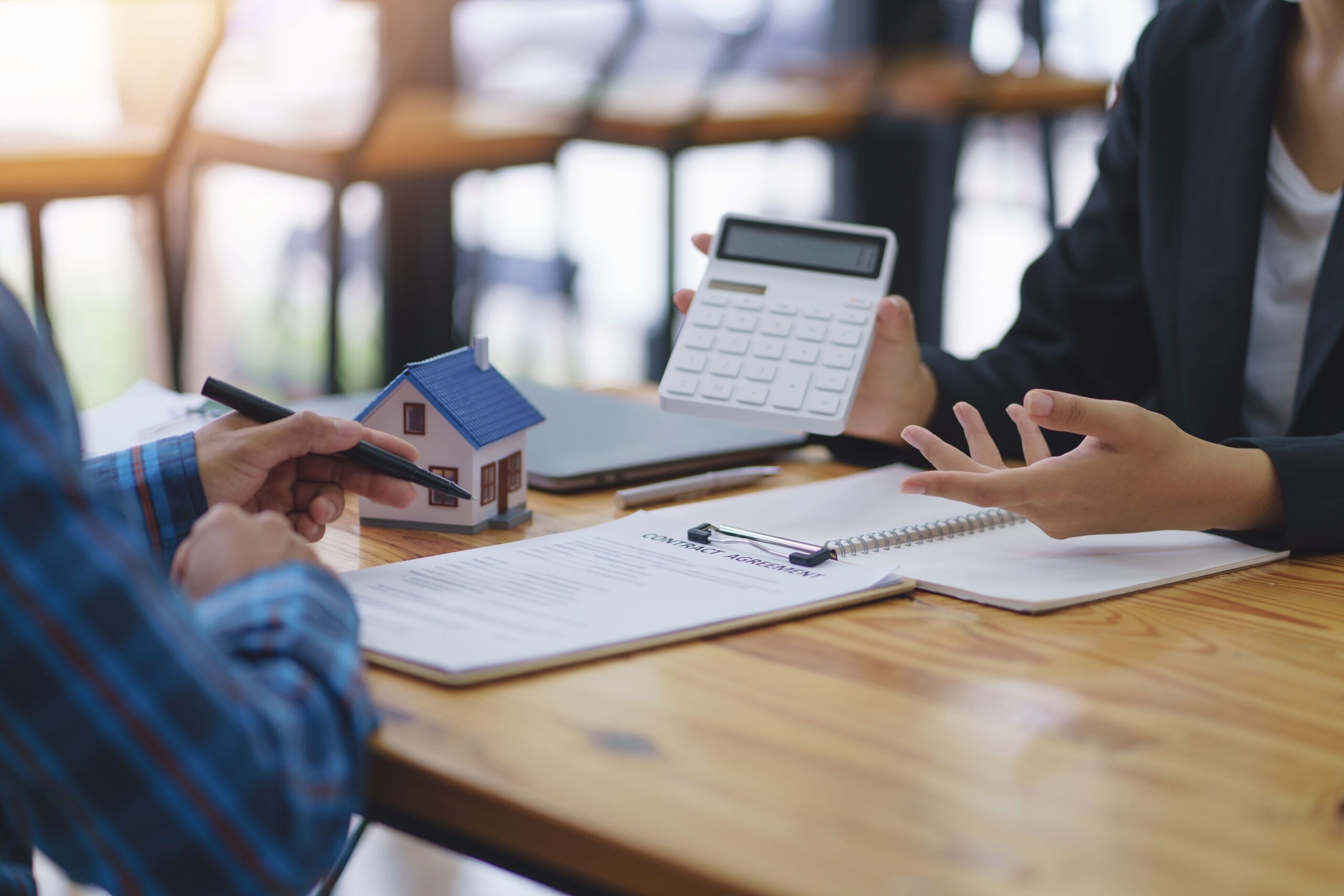 The real estate agent is explaining the home design to interested clients and signing an office sales contract.